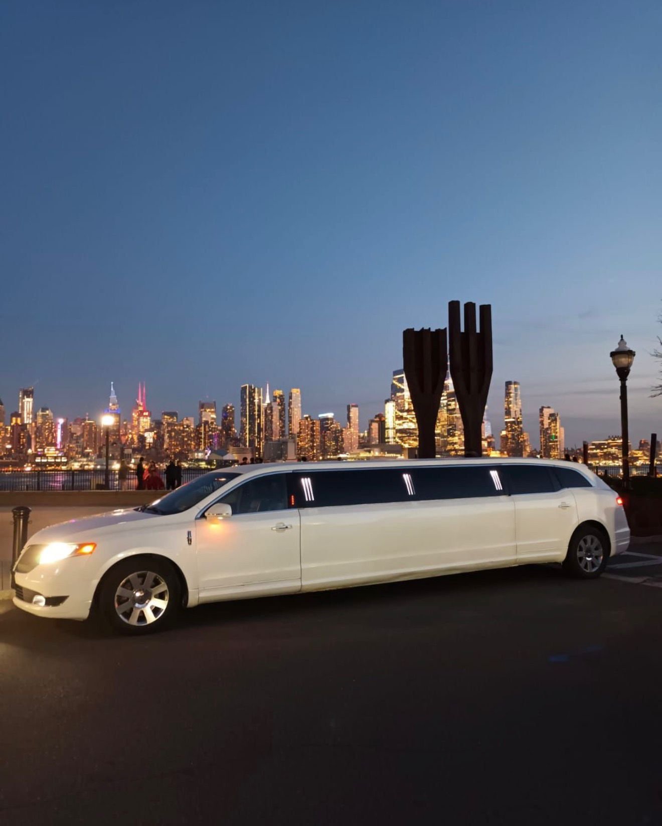 White stretch limousine by the New York City skyline for event transportation